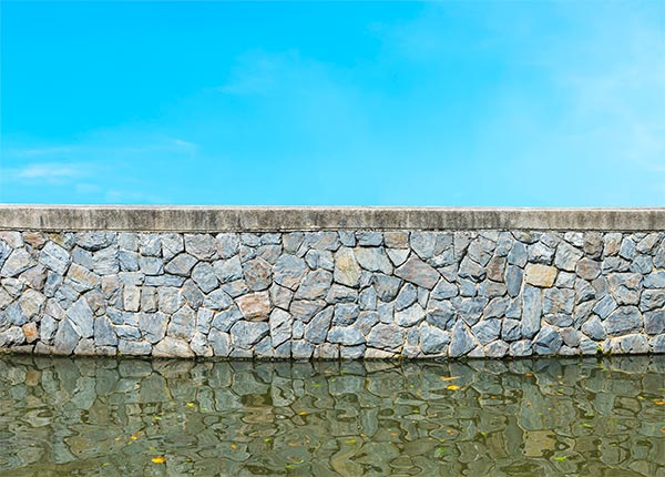 Fotografía de un muro de piedra de contención de agua
