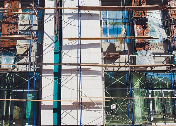 Fotografía de la fachada de un edificio en rehabilitación con andamios